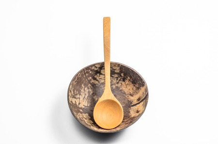 bowl made from Coconut shell with wooden spoon on white backgroundの写真素材