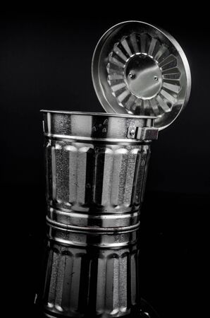 metal trash on black background with reflectionの写真素材
