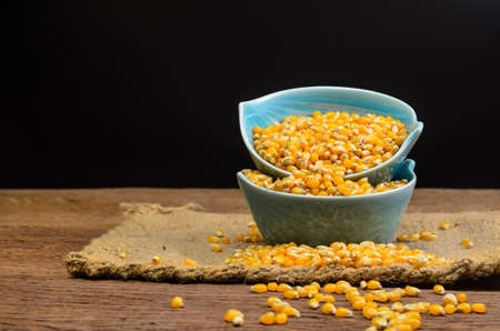 Dried corn seeds in blue ceramic bowl on wooden board,agriculture productの写真素材
