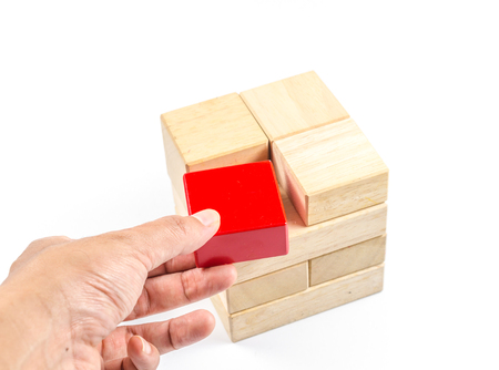 hand pick up wooden cube block to make structure isolated on white background,planning in business conceptの写真素材