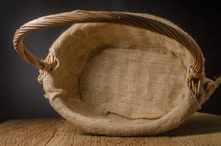 empty wicker basket on wooden boardの写真素材