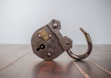 Old padlock on wooden board backgroundの写真素材