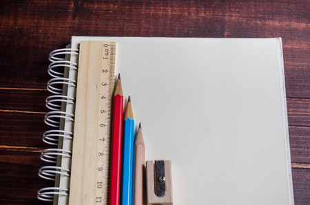 notebook with pencils on wooden tableの写真素材