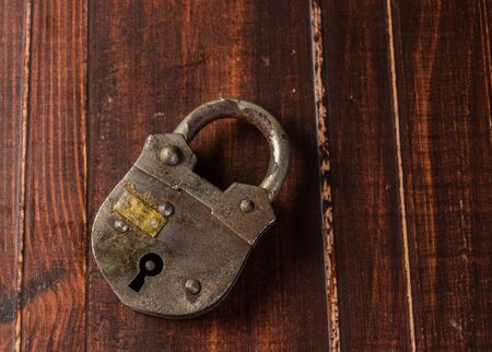 Old padlock on wooden board backgroundの写真素材