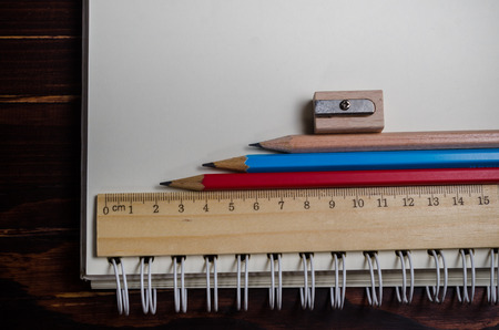 notebook with pencils on wooden tableの写真素材