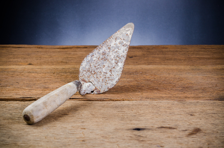 Old rusty trowel tools on wooden boardの写真素材