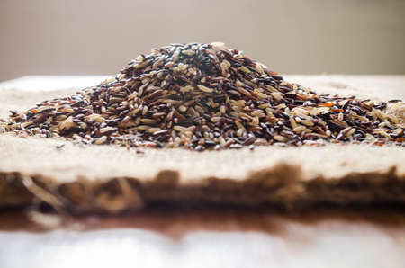 brown rice in wooden bowl on sackcloth backgroundの写真素材