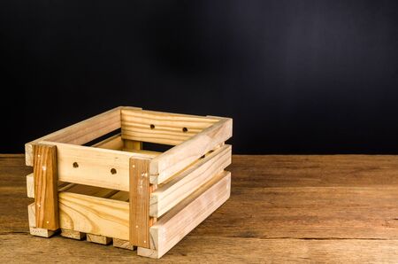 empty wooden crate on wooden board and black backgroundの写真素材