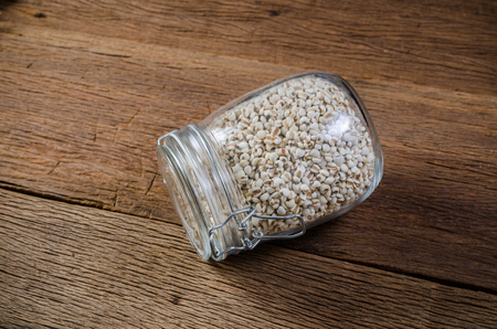 Job's tears in glass jar on wooden board, agriculture productsの写真素材