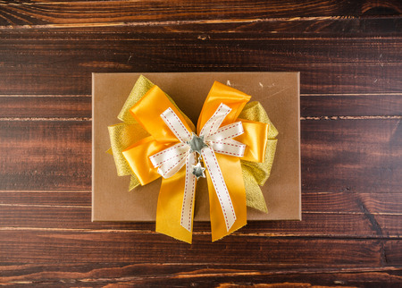 Brown gift box with white bow isolated on white backgroundの写真素材