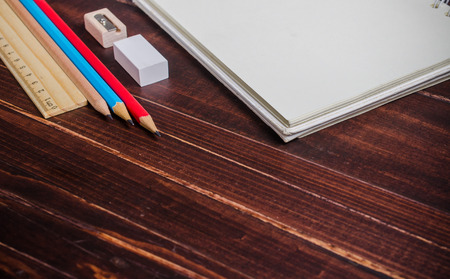 notebook with pencils on wooden tableの写真素材