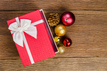 Red gift box with white bow on wooden board backgroundの写真素材