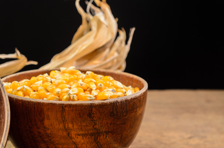 Dried corn seeds in wooden bowl on wooden board,agriculture productの写真素材