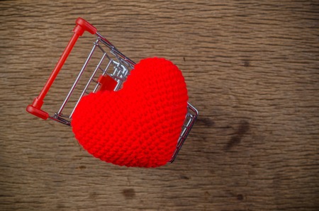 Red heart in shopping cart on wooden board , love valentine day conceptの写真素材