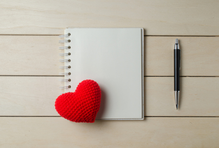 heart shape with notebook on wooden board , love valentine day conceptの写真素材