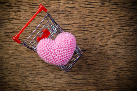 heart in shopping cart on wooden board , love valentine day conceptの写真素材