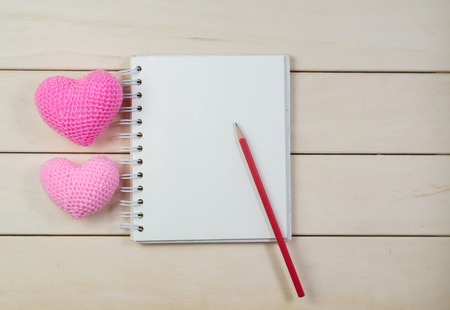 heart shape with notebook on wooden board , love valentine day conceptの写真素材