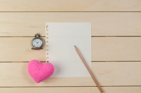 heart shape with blank paper and pocket watch on wooden board , love valentine day conceptの写真素材