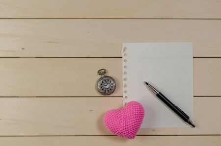 heart shape with blank paper and pocket watch on wooden board , love valentine day conceptの写真素材