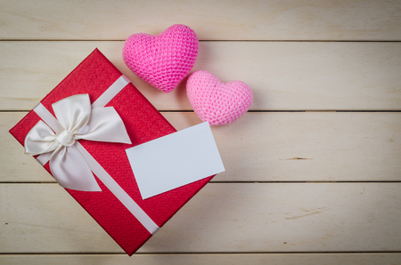 gift box with white bow and blank name card on wooden board backgroundの写真素材