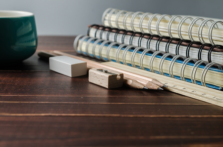 notebook with pencils on wooden tableの写真素材