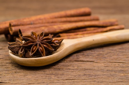 Star anise on wooden spoon and cinnamon stick on wooden board background,Chinese star aniseedの写真素材