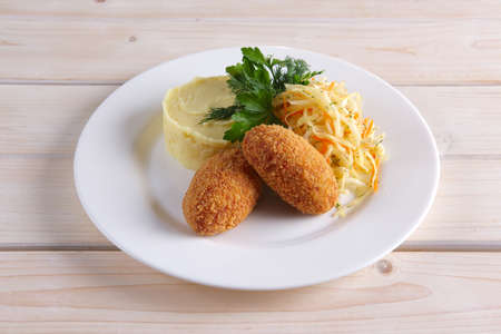 Chicken Kiev cutlet with pickled cabbage and mashed potatoの写真素材
