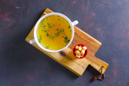 Plate with clear soup and pieces of white bread croutonの写真素材