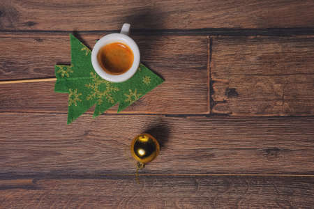 Top view of coffee cup and christmas tree toys on wooden tableの写真素材