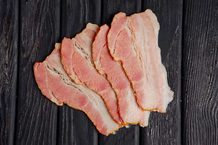 Top view of slices of fresh bacon on wooden tableの写真素材