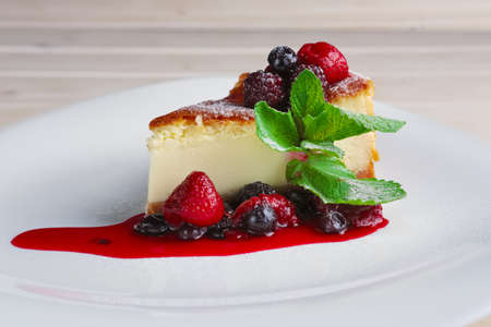 Cheesecake with berries sauce and green mint leaf.の写真素材