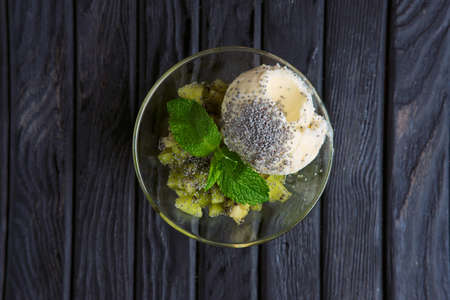 Top view of apple ice cream decorated with kiwi, mint leaves and poppyの写真素材