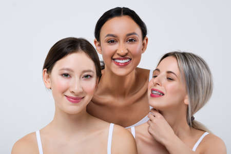 Happy asian, caucasian and african girls with different types of skin in white panties and shirt.の写真素材
