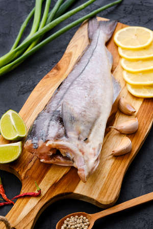 Raw fresh haddock carcass on wooden cutting boardの写真素材