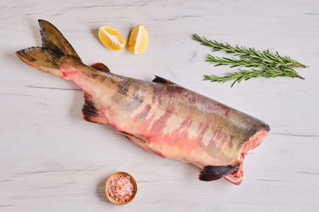 Frozen raw headless chum fish on light wooden backgroundの写真素材