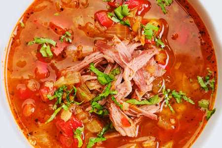Close up view of thick, spicy and sour soup with beef on dark wooden tableの写真素材