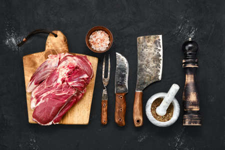 Overhead view of raw lamb shoulder without bone on wooden cutting boardの写真素材