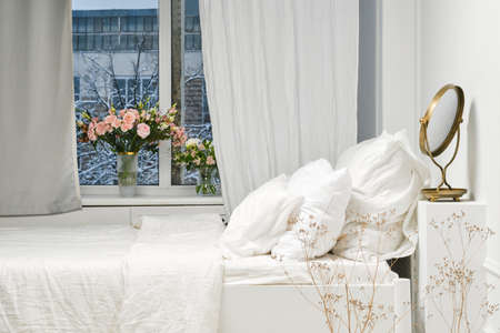 Side view of a bed with pillows in a loft roomの写真素材