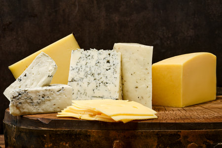 Assortment of different types of cheese on wooden blockの写真素材