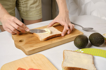 Hands of woman spreading soft cheese on toastの写真素材