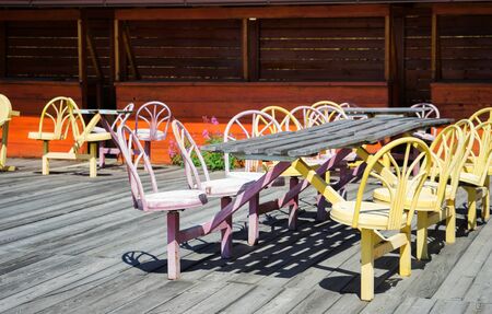 Old street cafe with wooden floor, wooden table and colored metal chairsの写真素材