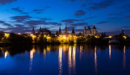 Several small towers near the lake at nightの写真素材
