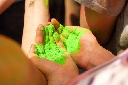 Bright green powder in hands, Holi festivalの写真素材