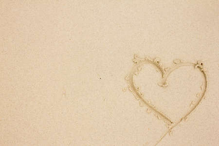 Heart drawn in the sand on the beachの写真素材