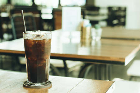Cold black coffee on the table in the coffee shop with vintage filter selective focusの写真素材