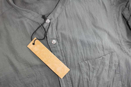 brown blank price tag on crumpled shirtの写真素材
