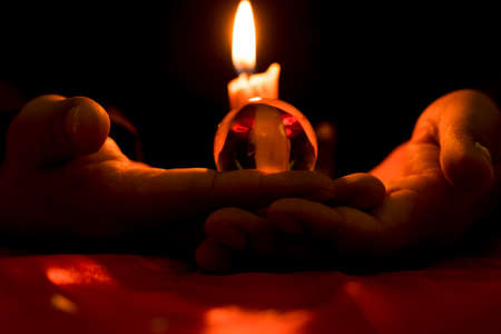 Mysterious hand casting rituals, using candles and crystal balls for superstitions.