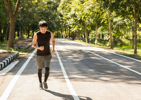 Asian men exercising running in the park for healthの写真素材