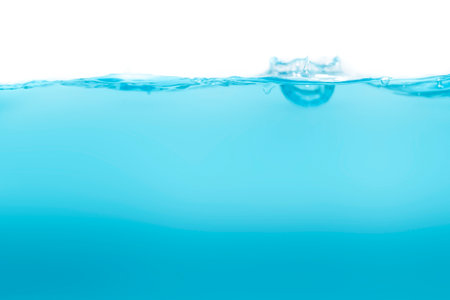 Drink clean blue water in a glass and the bubbles look like splashes and waves.の写真素材