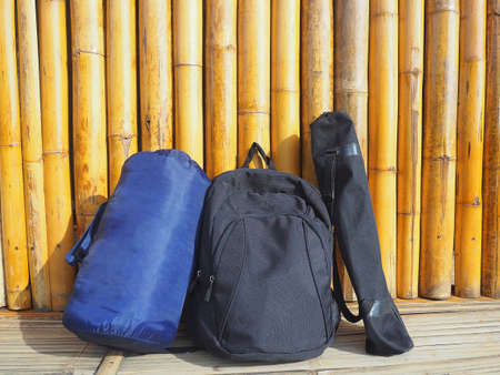Backpack, Sleeping bag on bamboo fence backgroundの写真素材